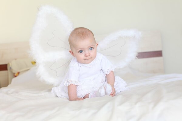 Chica con alas de ángel en la cama