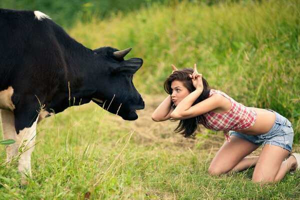 Chica jugando en el Prado con una vaca