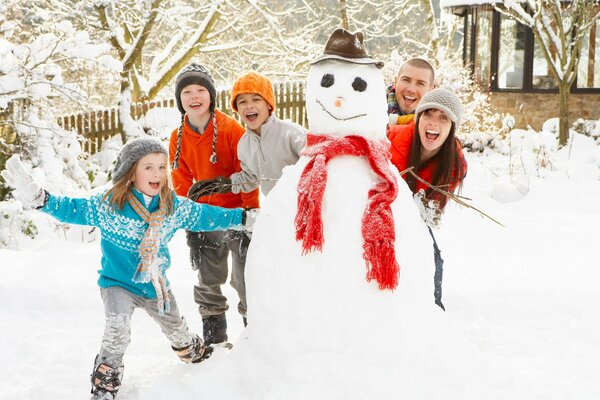 Foto di famiglia divertente invernale al pupazzo di neve