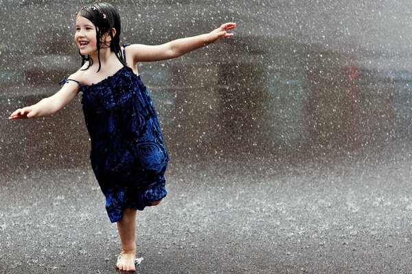 Fille en robe bleue sous la pluie