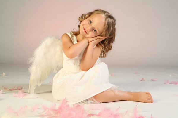 Маленькая девочка ангел мило улыбается