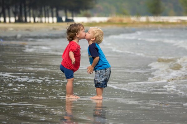 Lindo beso de niño y niña en la playa