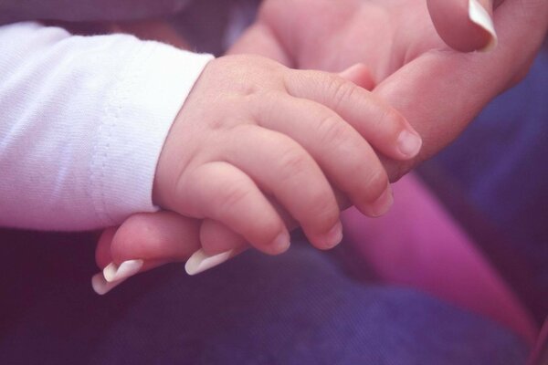 Hand in Hand:Die Handfläche des Babys in der Handfläche der Mutter