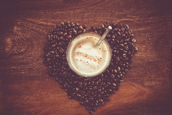 Café caliente sobre el fondo de los granos de café