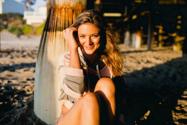 Chica sonriente en la playa en el sol