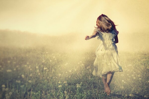 A girl in a white dress runs across the field