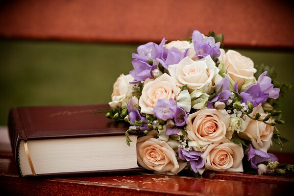 Un libro e un bellissimo bouquet su una panchina