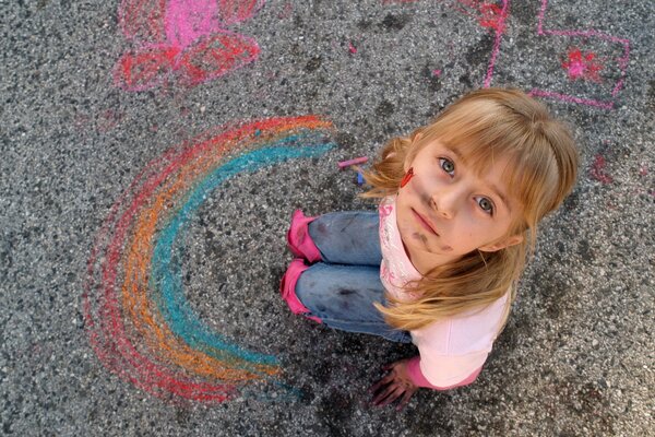 The soiled girl drew a rainbow on the asphalt