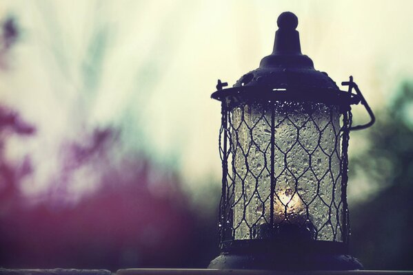 Lantern with a candle on a cloudy sky background