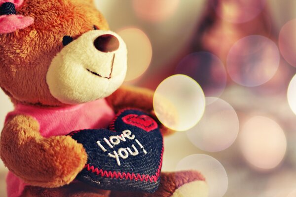 The bear holds a heart with the inscription I love you 