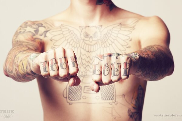 Un homme avec un torse nu sur ses mains tatouage véritable amour