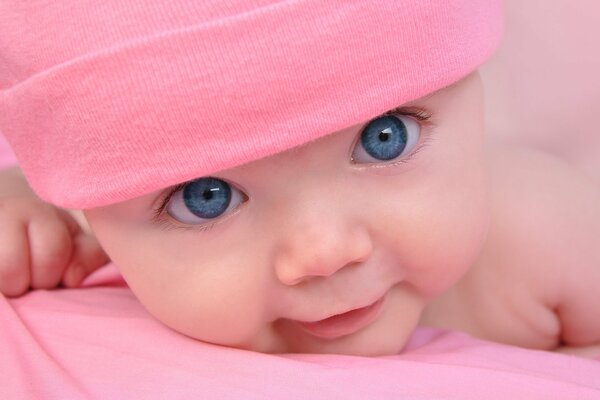 Schönes Baby mit blauen Augen in rosa Mütze