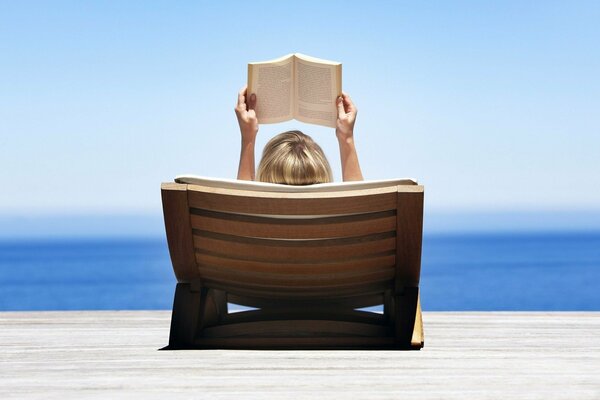 Chica de vacaciones junto al mar con un libro