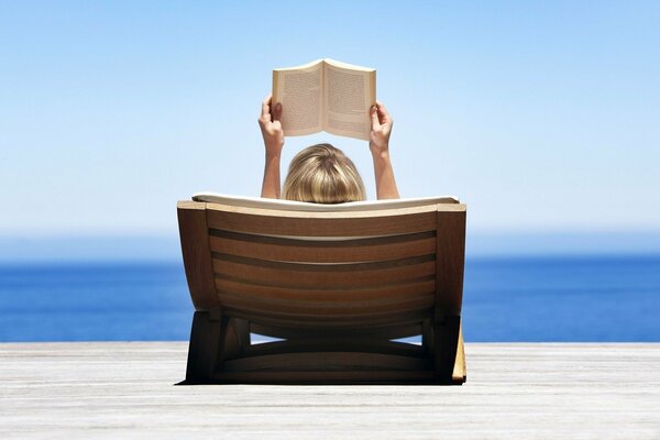 Fille en vacances au bord de la mer avec un livre