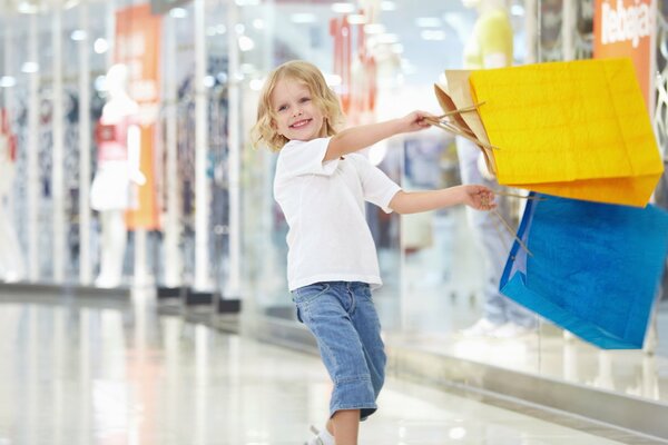 Bebé feliz con paquetes en las compras