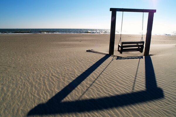 Swing on the sandy beach of the sea