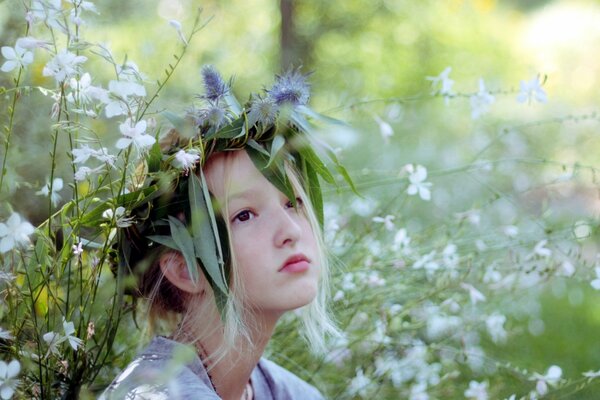 The girl is sitting in flowers