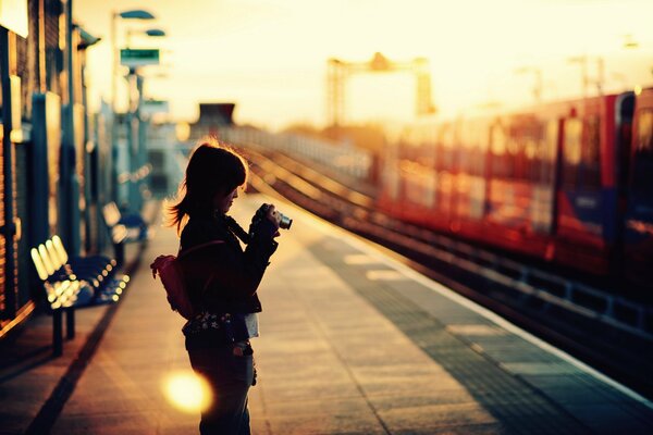 En el vogzal, una niña toma fotos de un tren