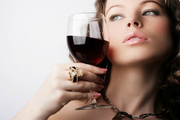 A glass of red wine in the girl s hands