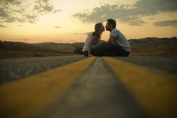 Pareja enamorada besándose en la carretera