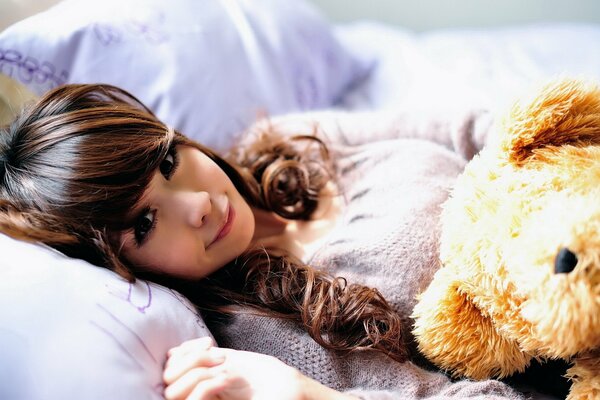 Una chica con un oso de peluche. Pijama