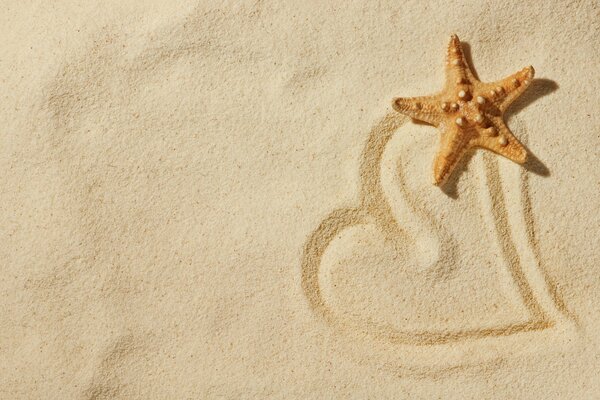 Cuore dipinto sulla sabbia con una stella