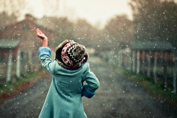 Ragazza sotto nevicate cattura mano fiocchi di neve