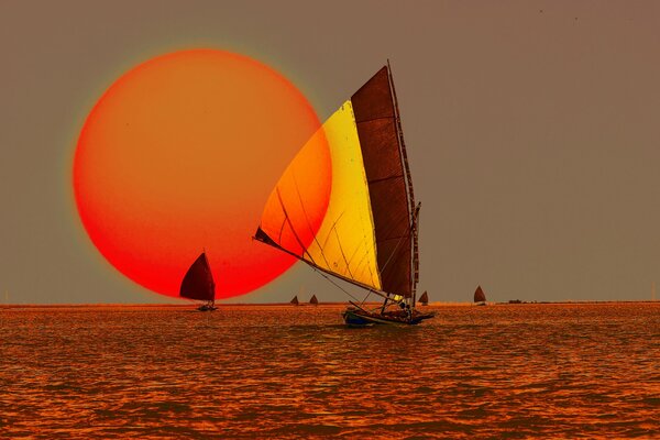 Insolite un coucher de soleil rouge de la mer et de la voile