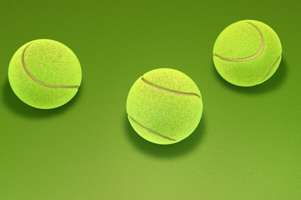 Three yellow tennis balls on a green background