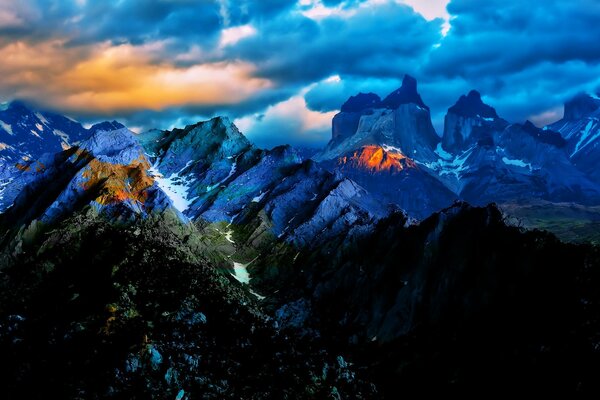 Paisaje de puesta de sol inusual en el fondo de montañas azules y nubes