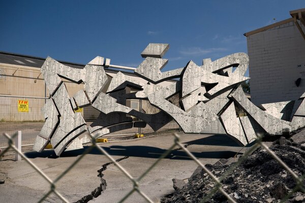 Graffiti tridimensionnel en métal derrière la clôture en maille