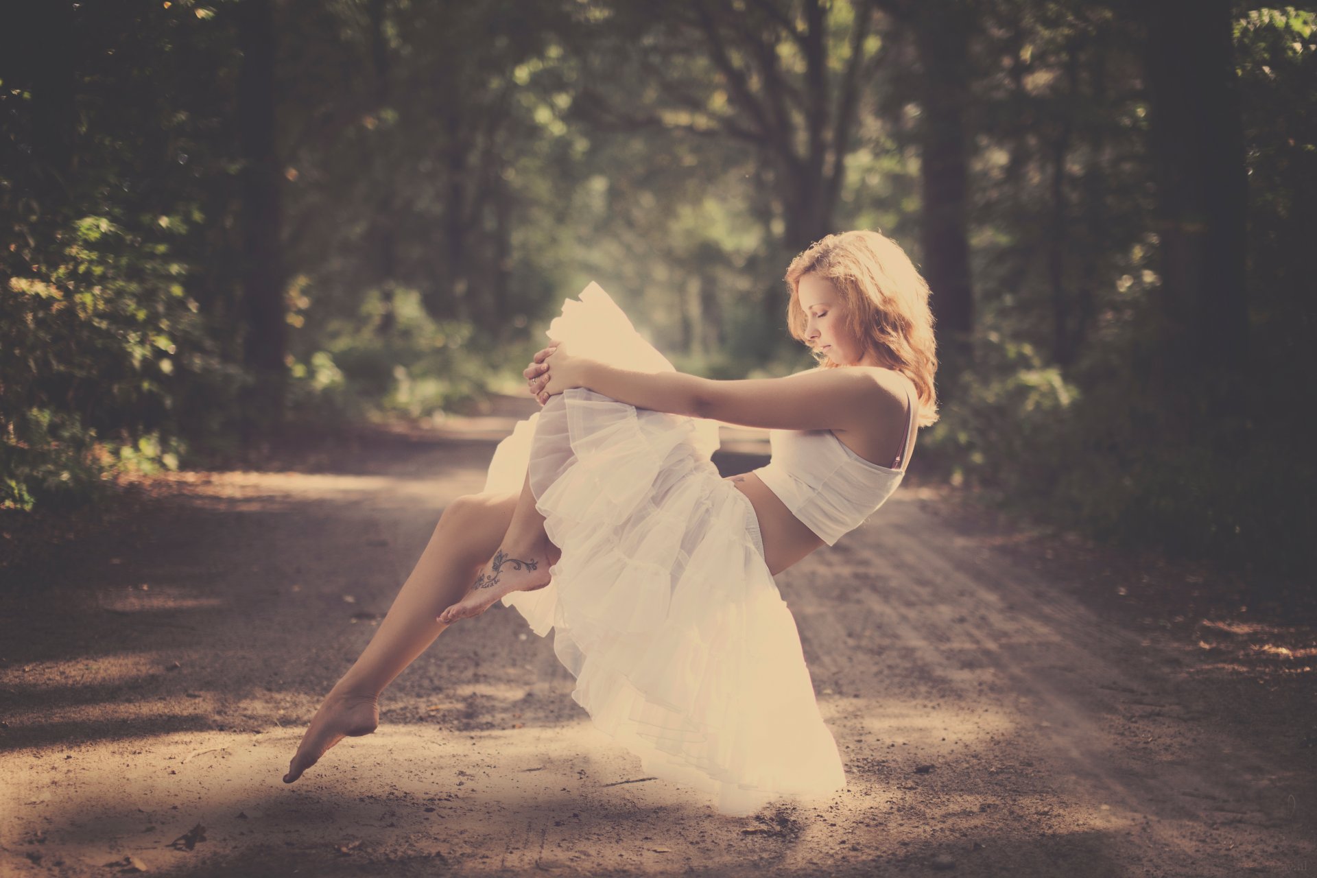 ragazza bionda levitazione strada foresta