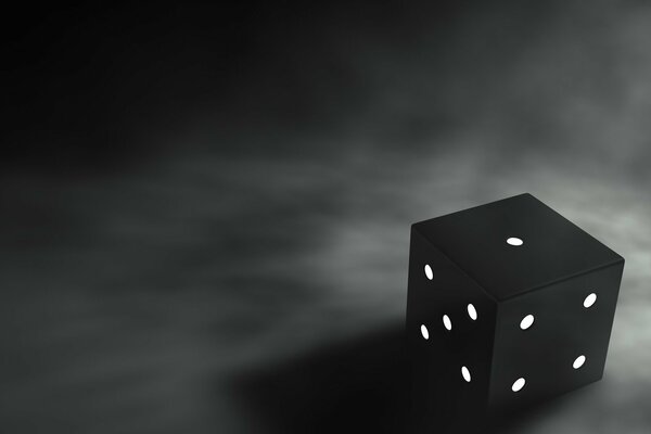 A black cube with white dots on a dark background