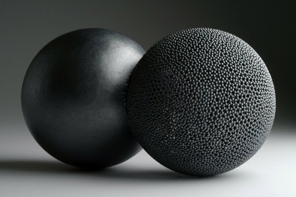 Two black balls on a white surface