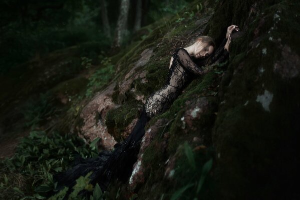 Composición con la naturaleza. Chica en vestido negro en el bosque