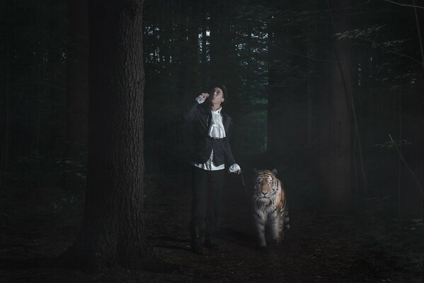A man with a tiger walking in the forest