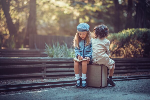 Cute kids sitting on a suitcase