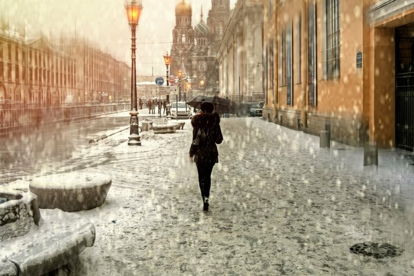 Chica con paraguas bajo la lluvia en la calle Peter