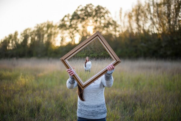 Photo of a girl with a mirror. Illusion