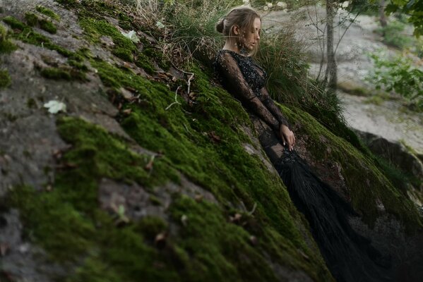 A girl in moss in a rocky area
