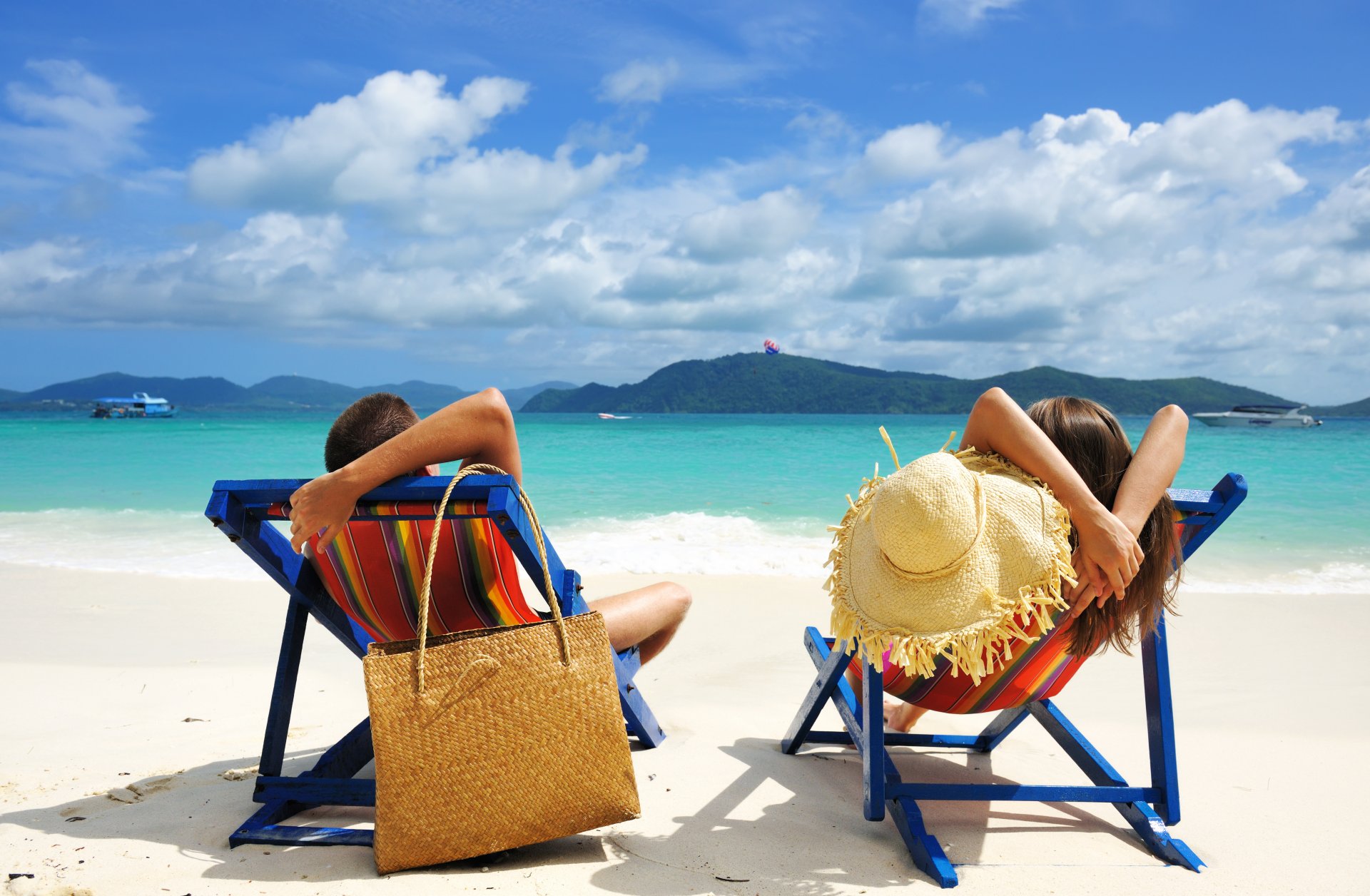 loisirs se détendre homme femme garçon fille plage sable mer eau ciel nuages îles chaises de plage sac chapeau été bateaux tropical paysage nature