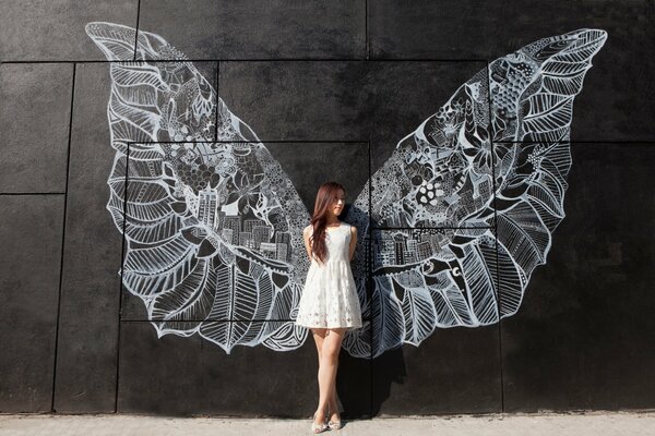 A girl in a white dress with wings