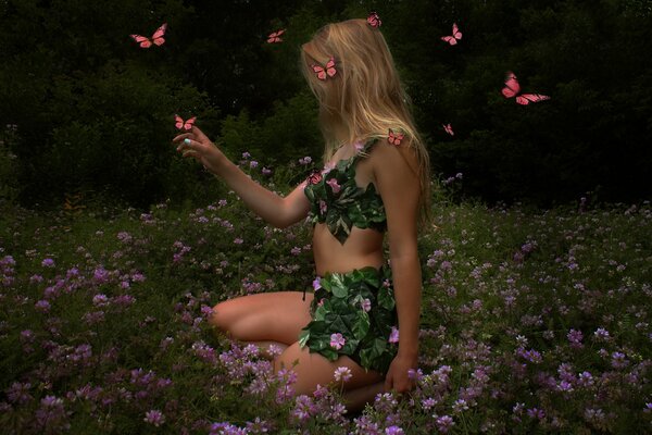 A girl in a clearing in flowers and butterflies