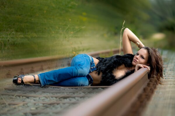 The girl loves speed lies on the rails