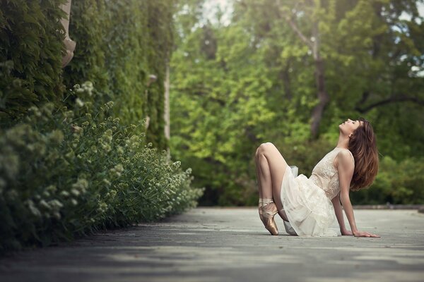 Beautiful girl in pointe shoes in a green forest