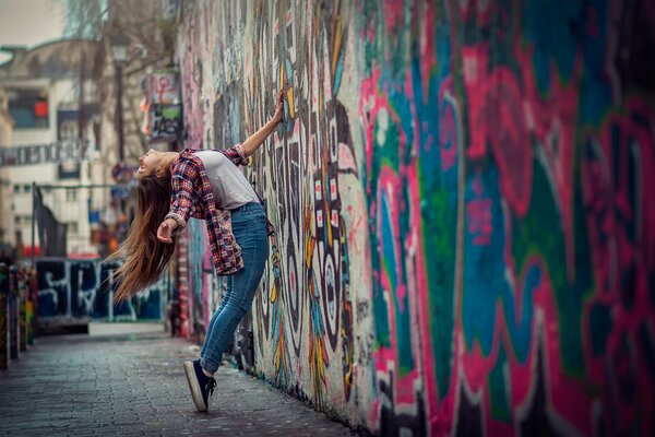 Ragazza in città vicino a bei graffiti