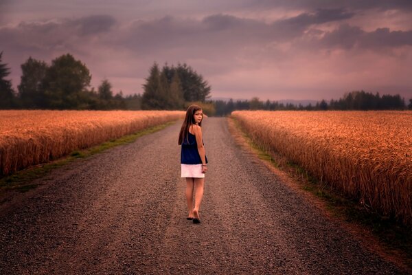 A girl walks barefoot on the road to the field