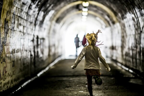 The girl runs through the tunnel after her parents