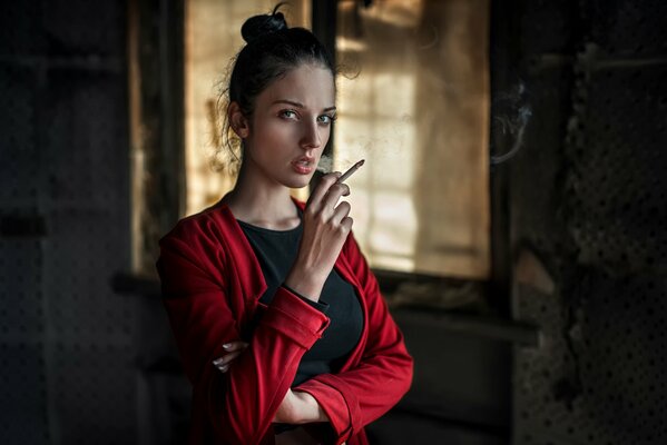 A girl in red with a cigarette in her hands