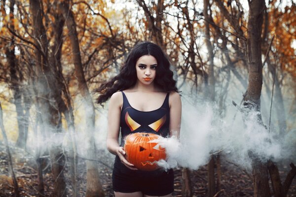 A girl with a pumpkin head in smoke